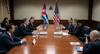 Diplomatic scene representing negotiations between the United States and Cuba with flags of both countries