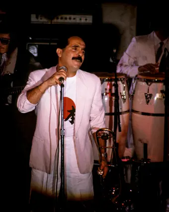 Willie Colón playing trombone on stage, salsa legend in New York