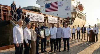 Empresarios cubanos y dueños de pymes recibiendo contenedores de combustible de un barco estadounidense en el puerto de La Habana