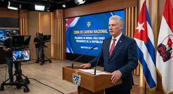 President Miguel Díaz-Canel addressing the nation in a professional news setting with the Cuban flag in the background.
