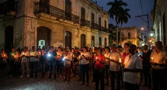 People in a dark Cuban street at night, illuminated only by candles during a massive blackout