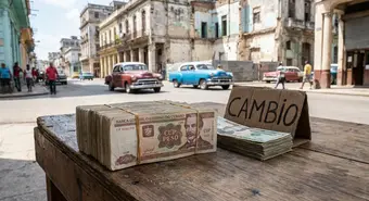 Banknotes of Cuban pesos and US dollars on a wooden table on a street in Havana.