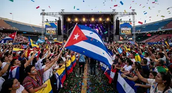 Latin American flags including the Cuban flag waving in a stadium during a musical performance. Illustration.