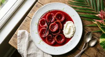 Cuban casquitos de guayaba (guava shells) in syrup served with cream cheese on a white plate