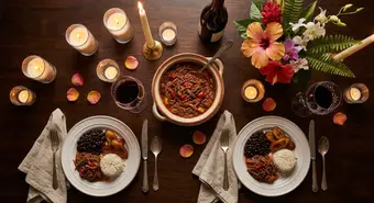 Elegant romantic Cuban dinner table setting with candles and tropical flowers