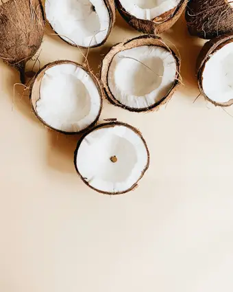 Coco rallado y dulces de coco sobre superficie de madera. Foto: Unsplash