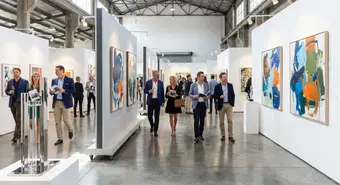 Contemporary art fair interior with visitors viewing modern installations. Illustrative image.