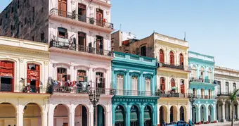 Scaffolding in front of a colonial building in Old Havana with a freshly restored facade in ochre and blue tones