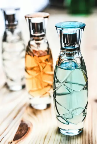 Frascos de perfume elegantes sobre superficie de madera. Foto: Pexels