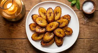 Golden caramelized Cuban fried sweet plantains on a white plate