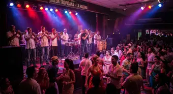 Cuban timba band performing live on a Havana stage with brass, congas, and colorful lights
